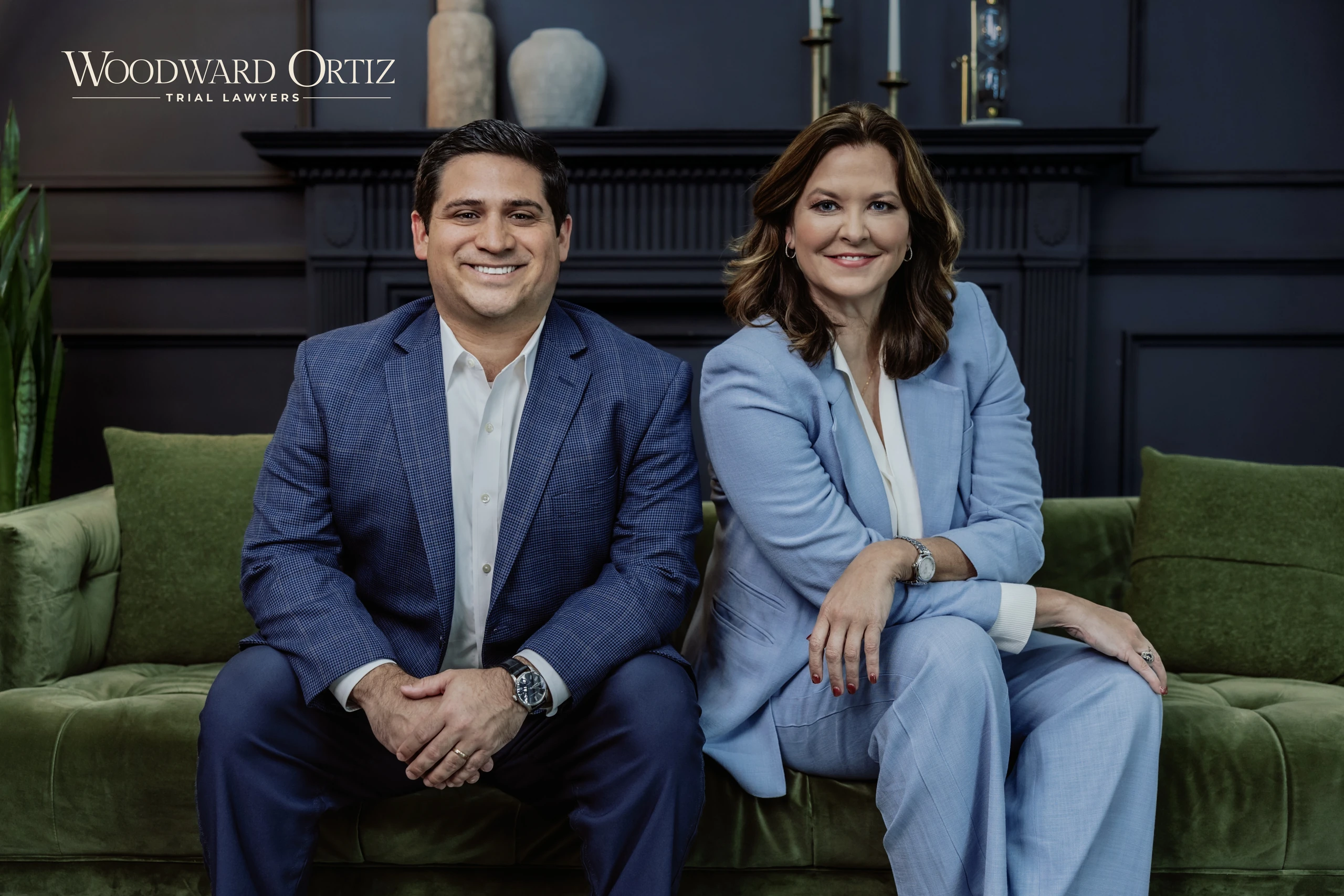 Will Ortiz y Natalie Woodward sentados junto al logotipo de Woodward Ortiz